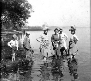 Women and children wade in the water.  Women and children wade in the water.